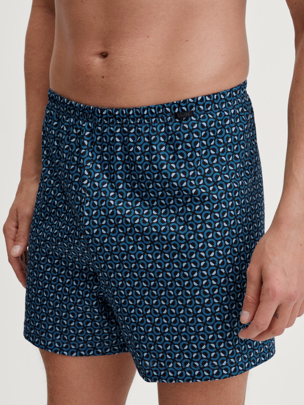Herren-Model trägt Jersey-Boxershorts ohne Eingriff aus 100% Baumwolle in Blau, Gemustert aus Serie Prints von CALIDA, Vorderansicht