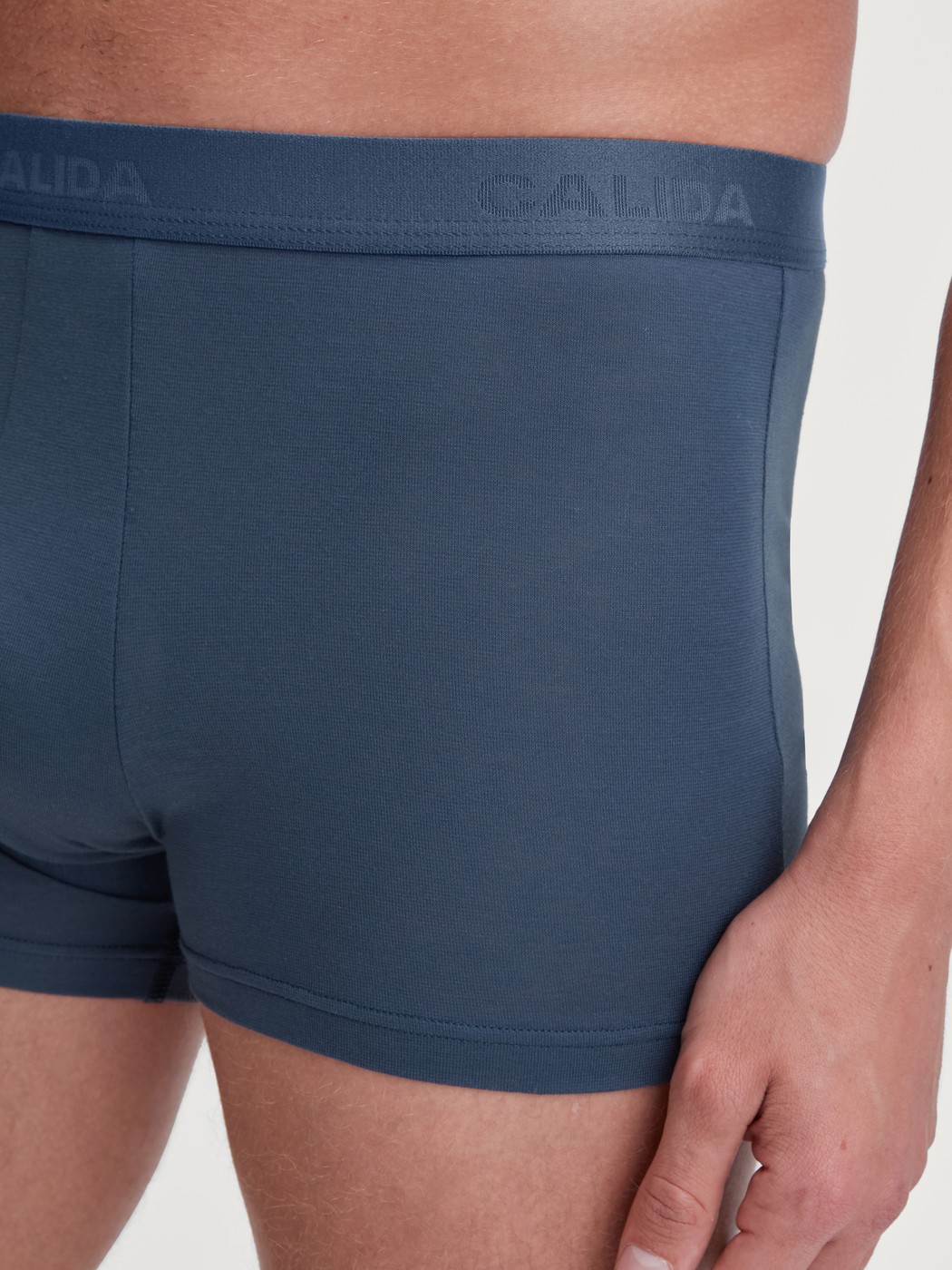 Herren-Model trägt Boxer Brief mit Softbund aus Baumwolle in Blau, Einfarbig aus Serie Evolution von CALIDA, Detail