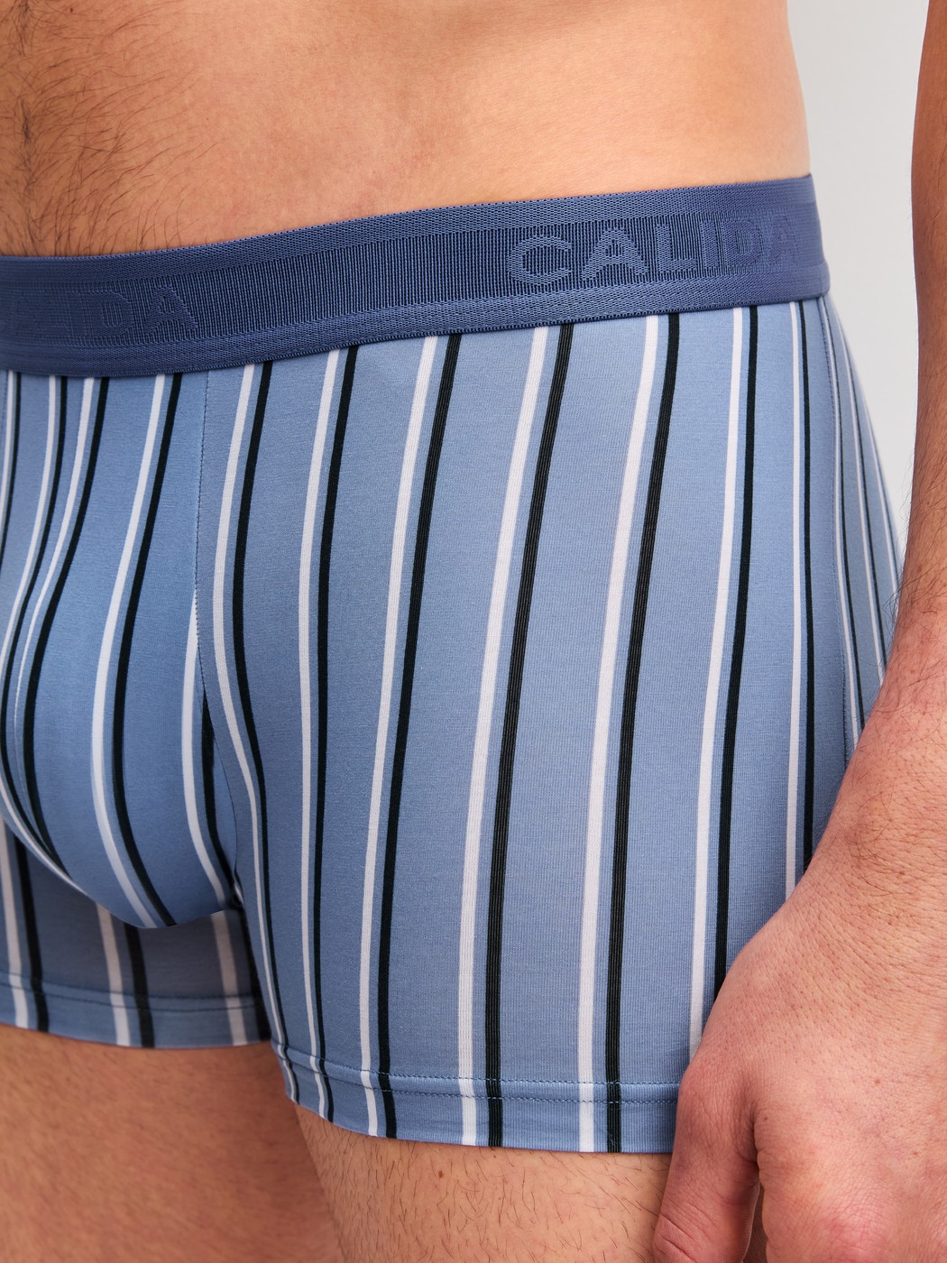 Herren-Model trägt Boxer Brief mit Softgummibund aus Pima® Baumwolle in Blau, Gestreift aus Serie Grafic Cotton von CALIDA, Detail