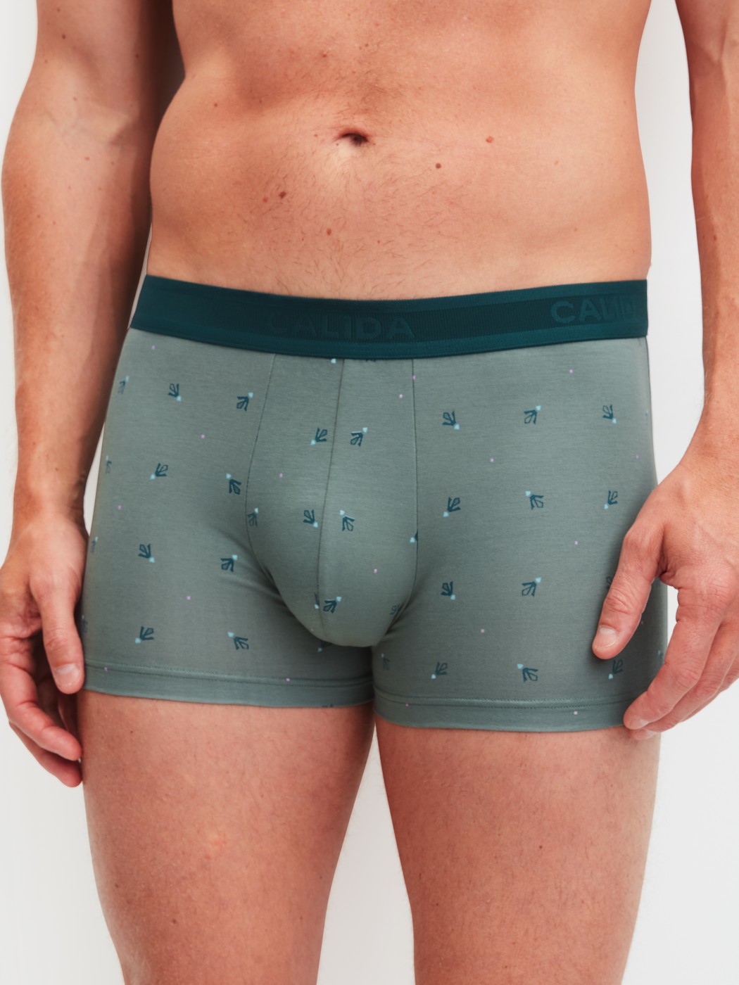 Herren-Model trägt Boxer Brief mit Softgummibund aus Baumwolle in Grün, Gemustert aus Serie Grafic Cotton von CALIDA, Vorderansicht