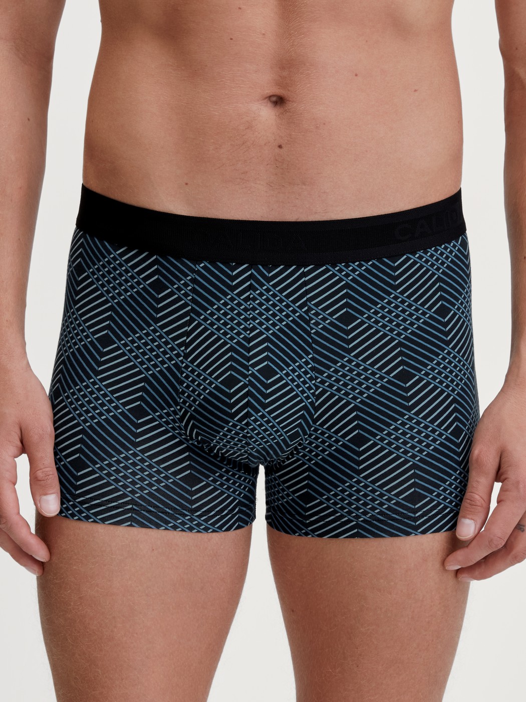 Herren-Model trägt Boxer Brief mit Softgummibund aus Baumwolle in Schwarz, Gemustert aus Serie Grafic Cotton von CALIDA, Vorderansicht