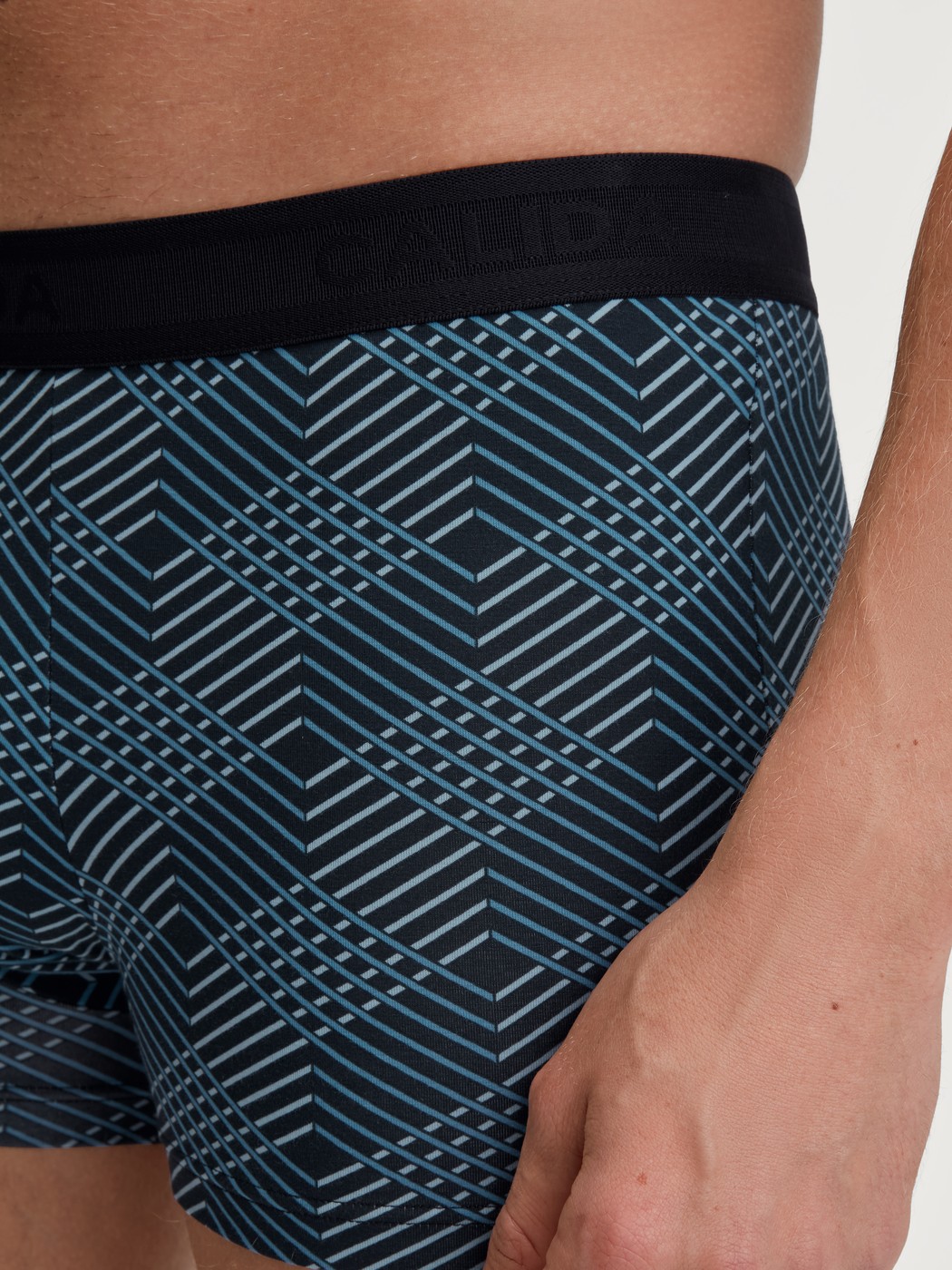 Herren-Model trägt Boxer Brief mit Softgummibund aus Baumwolle in Schwarz, Gemustert aus Serie Grafic Cotton von CALIDA, Detail