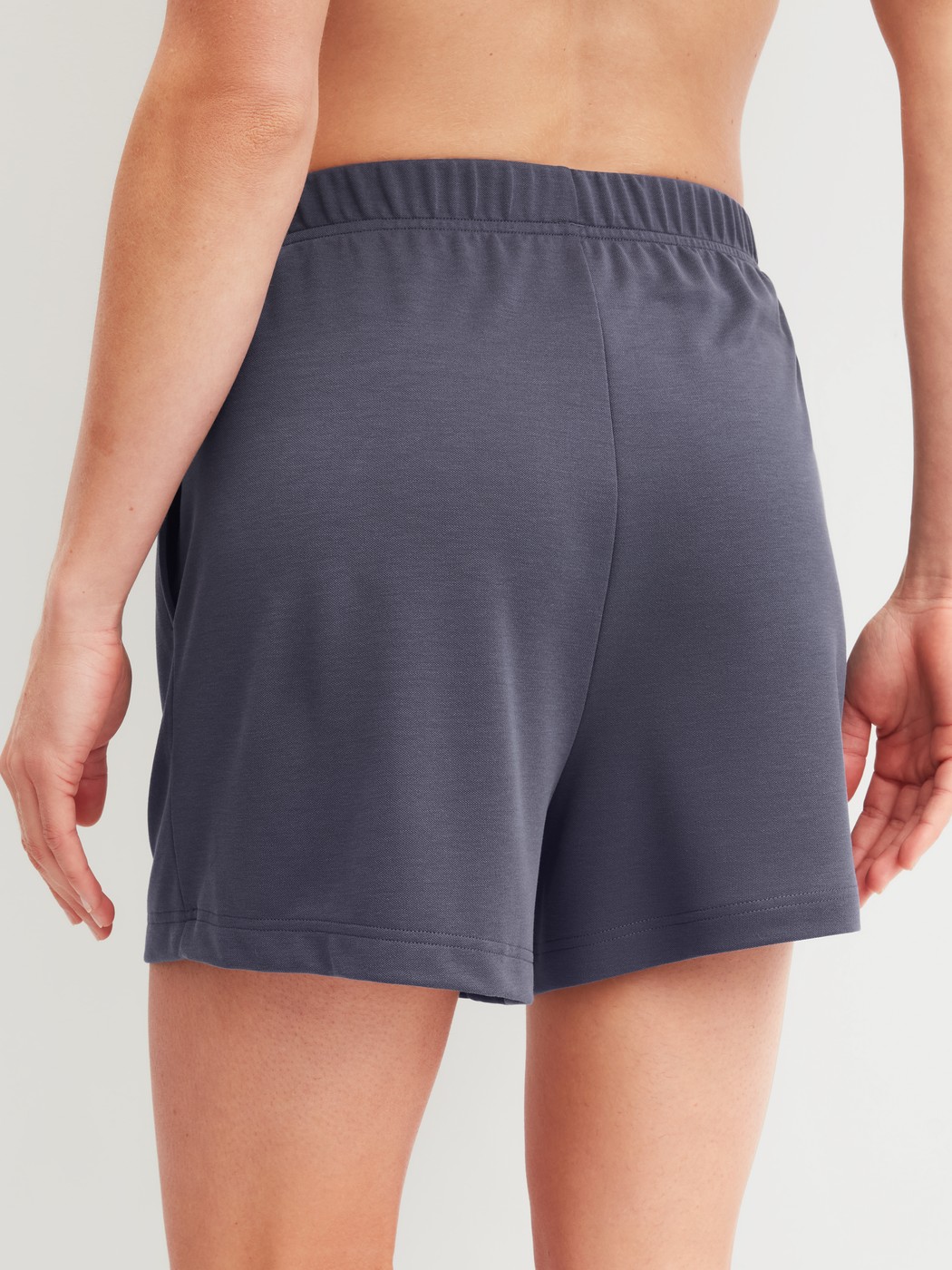 Damen-Model trägt Loungeshorts aus Modal in Blau, Einfarbig aus Serie Natural Loungewear von CALIDA, Rückansicht