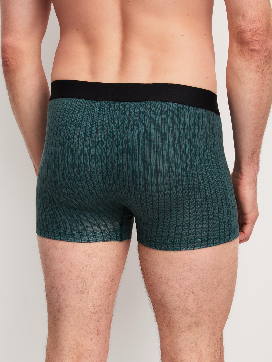 Herren-Model trägt Boxer Brief mit Softgummibund aus Baumwolle in Türkis, Gemustert aus Serie Cotton Code Design von CALIDA, Rückansicht