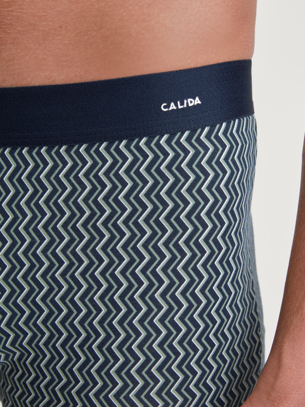 Herren-Model trägt Boxer Brief mit Softgummibund aus Baumwolle in Grün, Gemustert aus Serie Cotton Code Design von CALIDA, Detail
