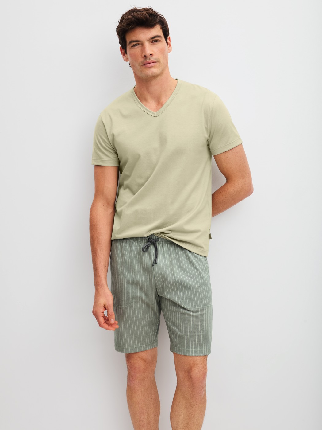 Men model is wearing Bermudas made of 100% Cotton in Green, Unicoloured from the RMX Sleep Leisure series by CALIDA, Outfit