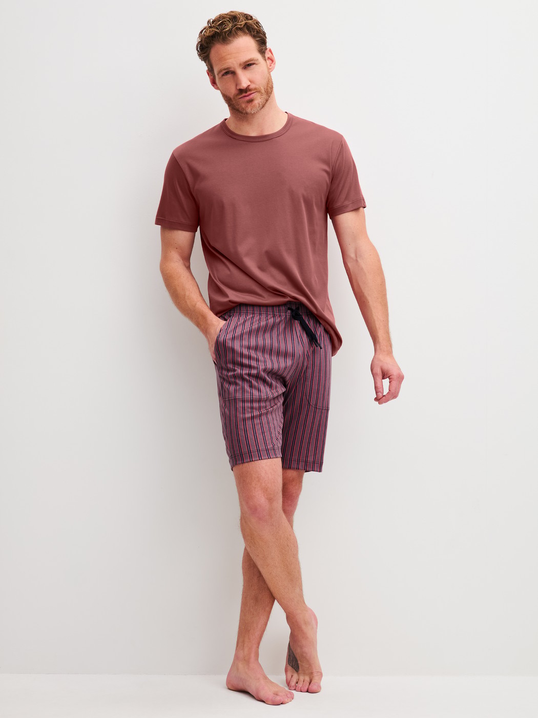 Herren-Model trägt Bermudas mit Seitentaschen aus Baumwolle in Braun, Gestreift aus Serie RMX Sleep Superlight von CALIDA, Outfit
