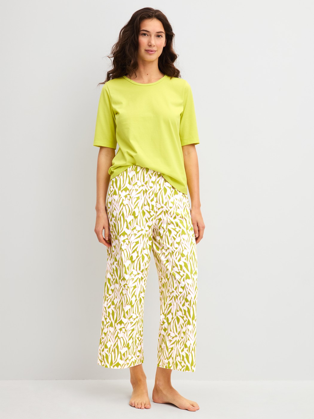 Damen-Model trägt 7/8-Pyjamahose aus 100% Baumwolle in Grün, Floral aus Serie Late Bloom M&M von CALIDA, Outfit