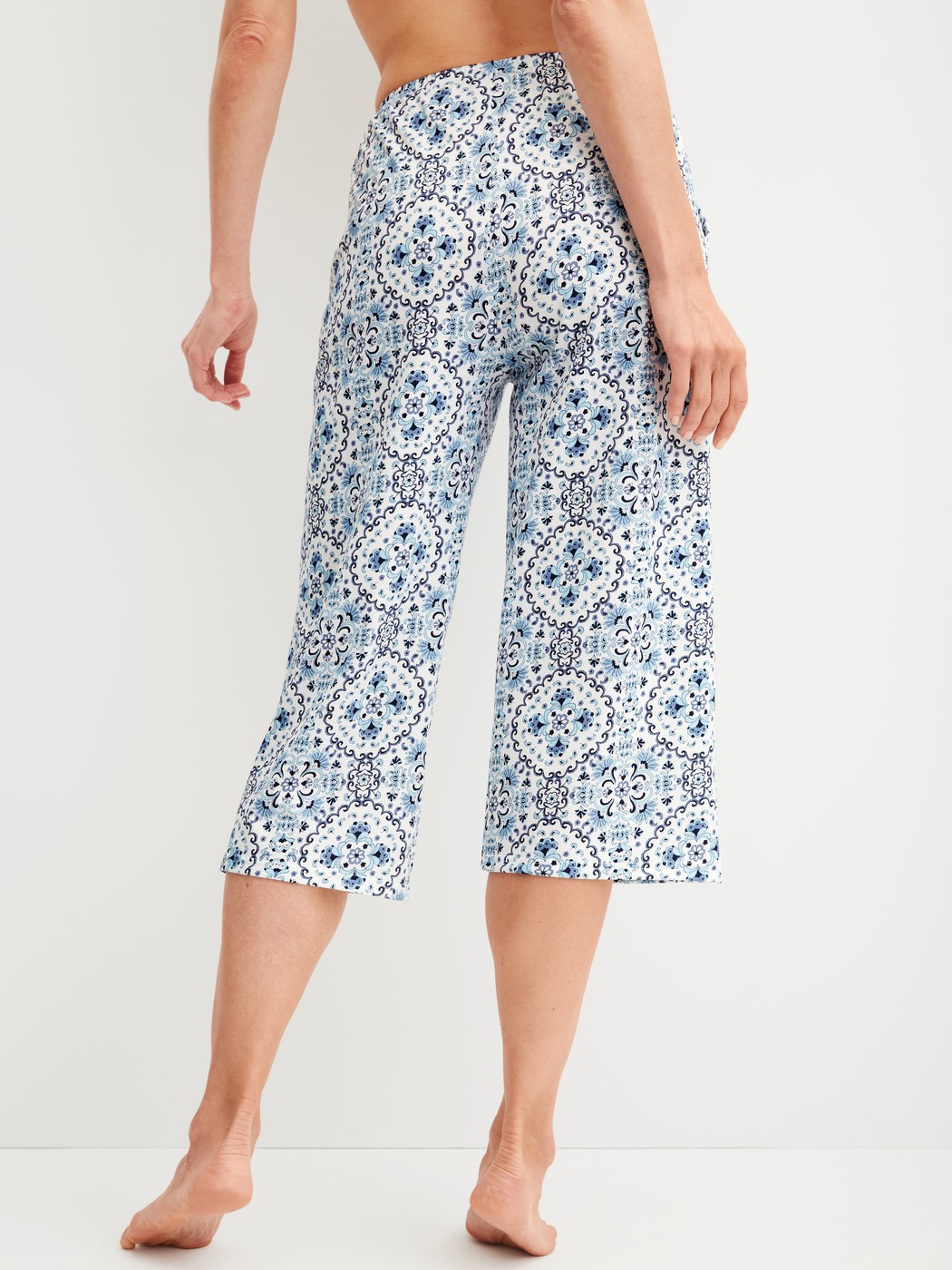 Damen-Model trägt 3/4-Pyjamahose aus 100% Baumwolle in Blau, Gemustert aus Serie Favourites Tiles von CALIDA, Rückansicht
