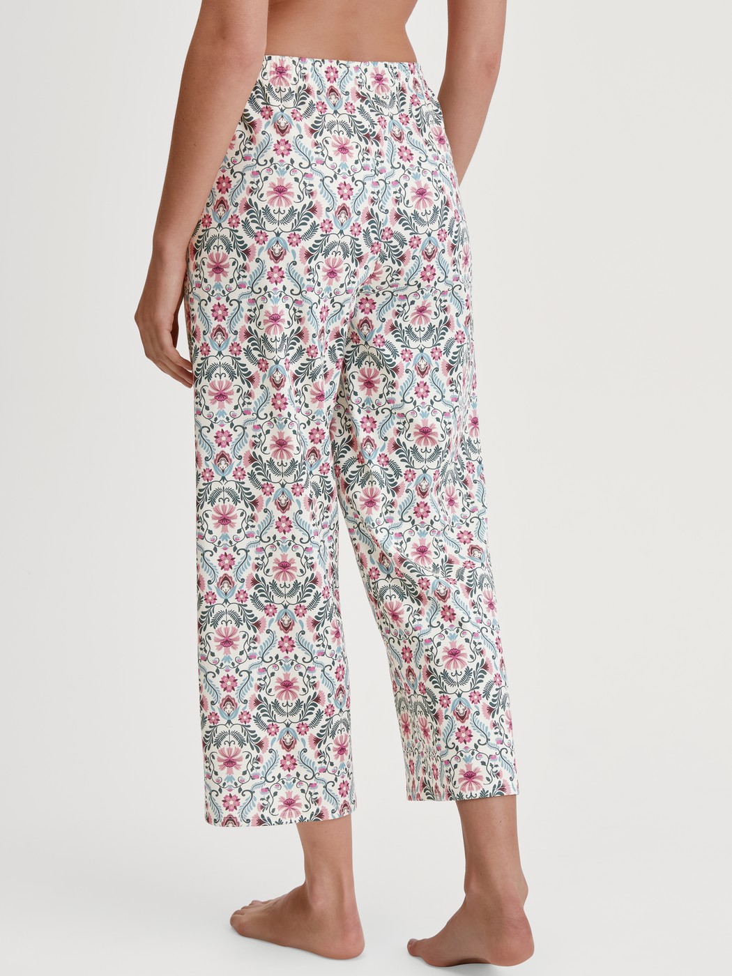 Women model is wearing 7/8 Pyjama bottom made of 100% Cotton in Pink, Patterned from the Favourites Botanic series by CALIDA, Back view