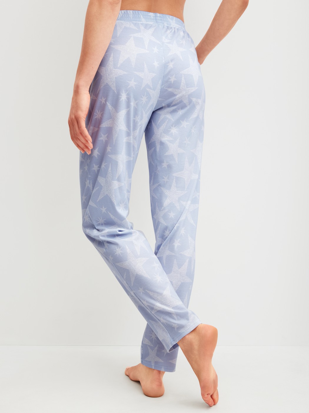 Damen-Model trägt Pyjamahose aus 100% Baumwolle in Blau, Gemustert aus Serie Favourites Cosy von CALIDA, Rückansicht