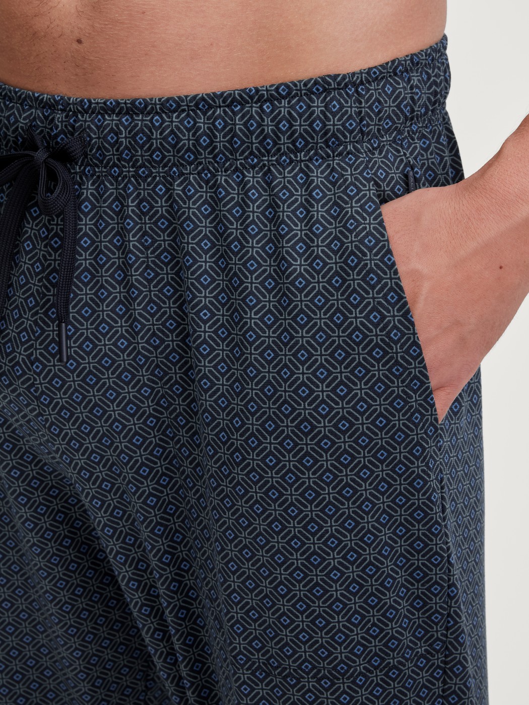 Herren-Model trägt Pyjamahose mit Seitentaschen aus 100% Baumwolle in Blau, Gemustert aus Serie RMX Sleep Weekend von CALIDA, Detail