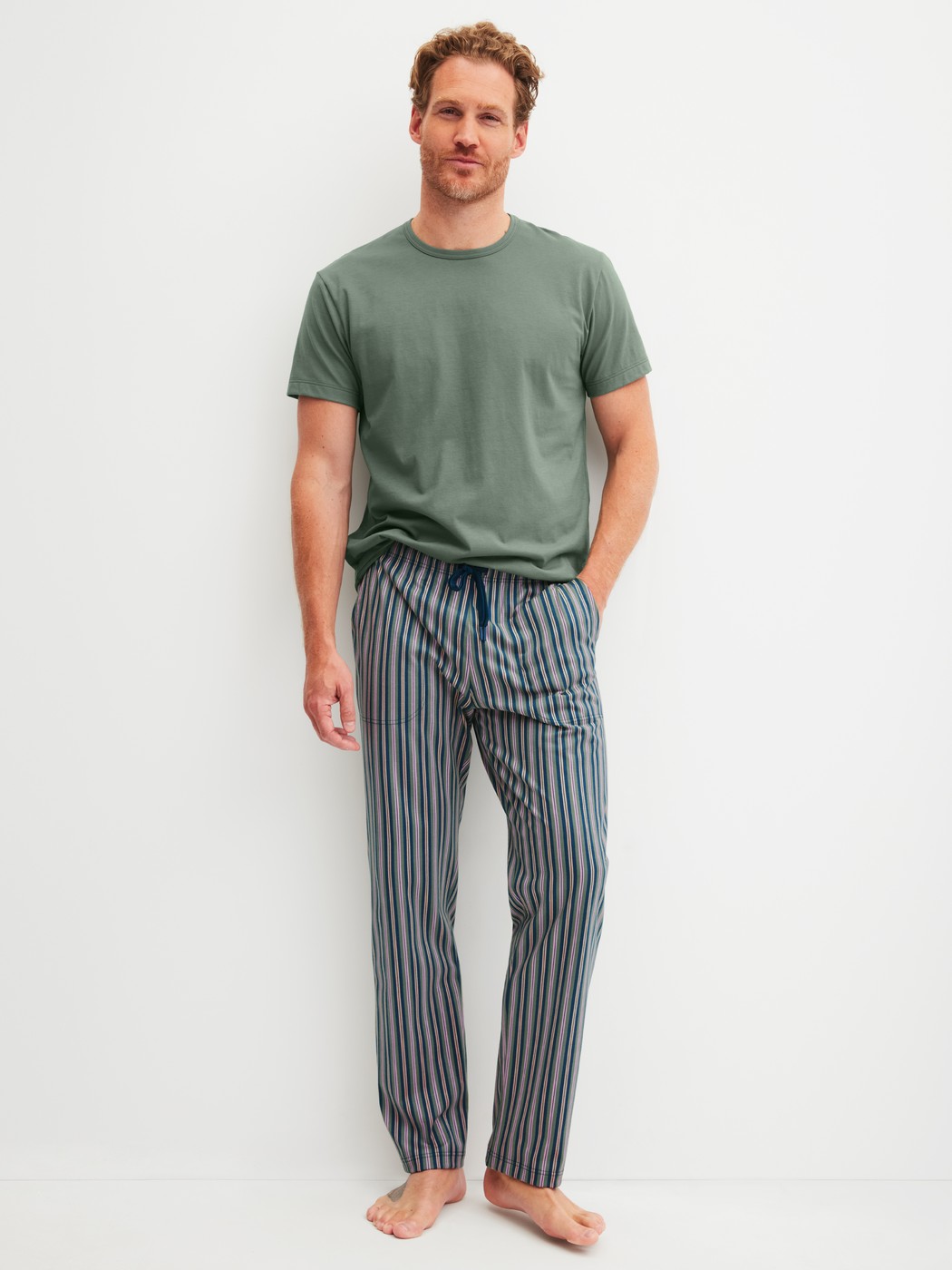 Men model is wearing Pyjama Bottoms with Side Pockets made of 100% Cotton in Green, Striped from the RMX Sleep Leisure series by CALIDA, Outfit