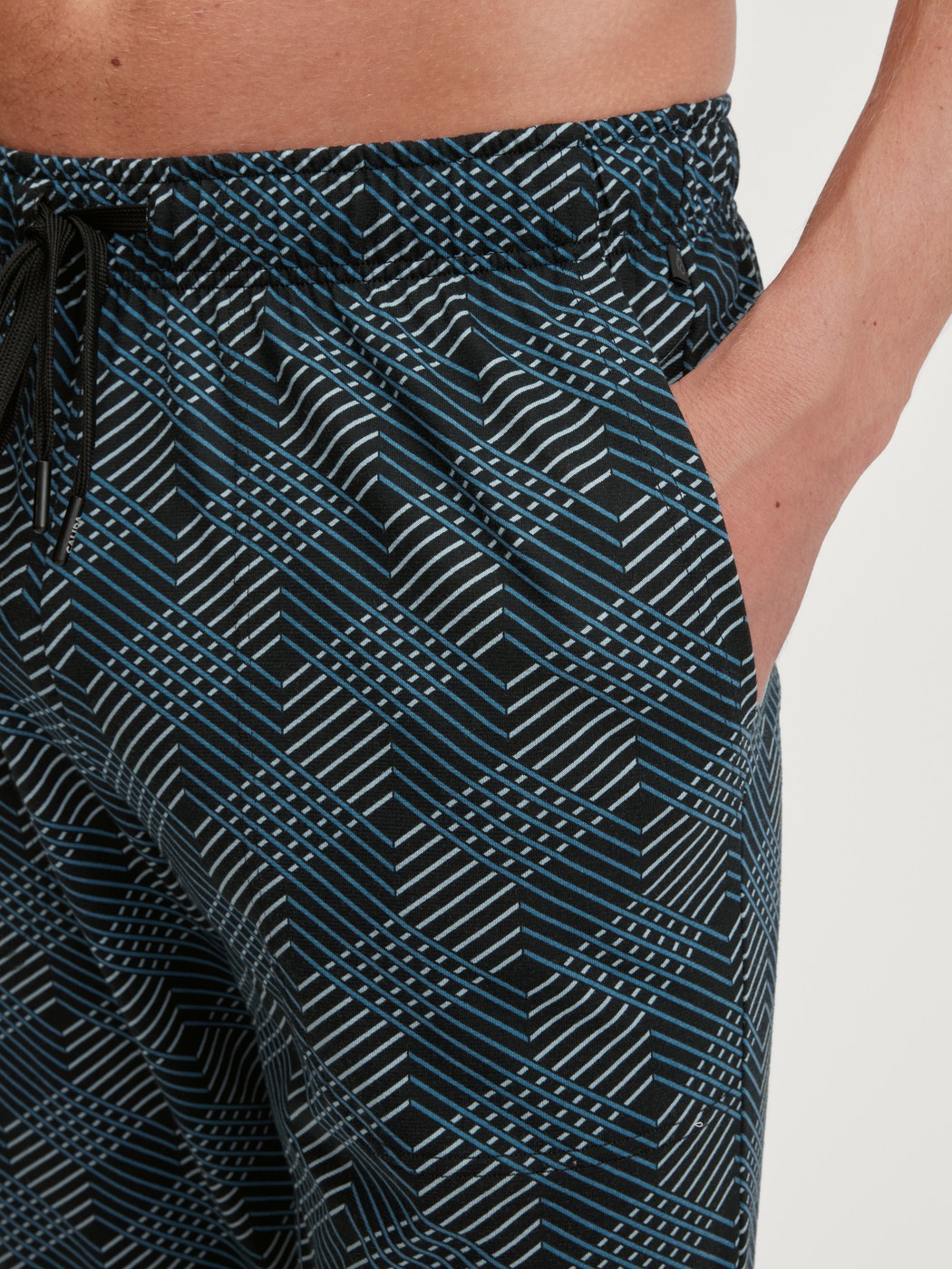 Herren-Model trägt Pyjamahose mit Seitentaschen aus 100% Baumwolle in Schwarz, Gemustert aus Serie RMX Sleep Leisure von CALIDA, Detail