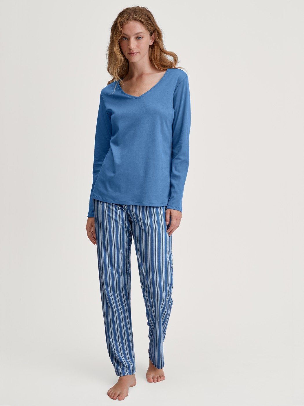 Damen-Model trägt Pyjamahose aus 100% Baumwolle in Blau, Gestreift aus Serie Favourites Journey von CALIDA, Outfit