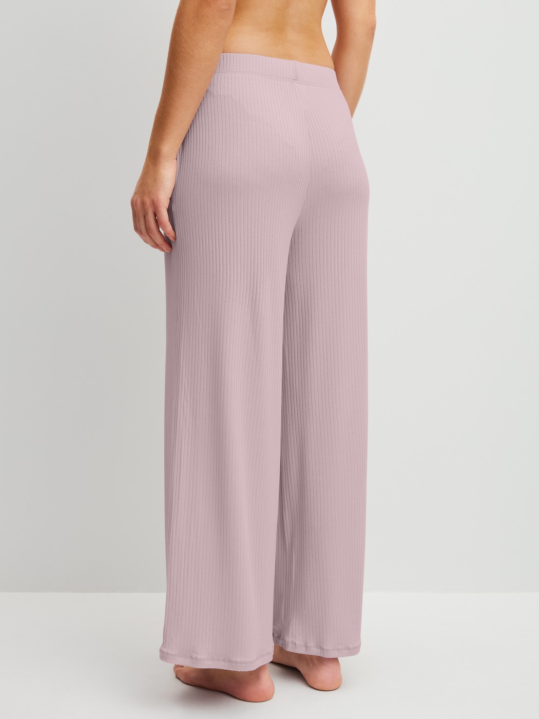 Damen-Model trägt Loungehose aus TENCEL™ Modal aus Modal in Violett, Einfarbig aus Serie Feminine Lounge von CALIDA, Rückansicht