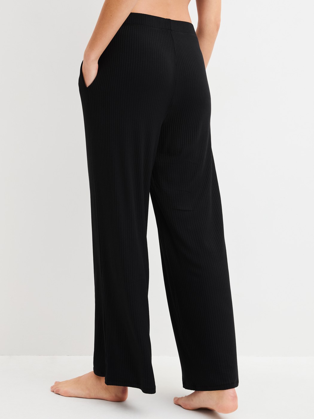Damen-Model trägt Loungehose aus TENCEL™ Modal aus Modal in Schwarz, Einfarbig aus Serie Feminine Lounge von CALIDA, Rückansicht