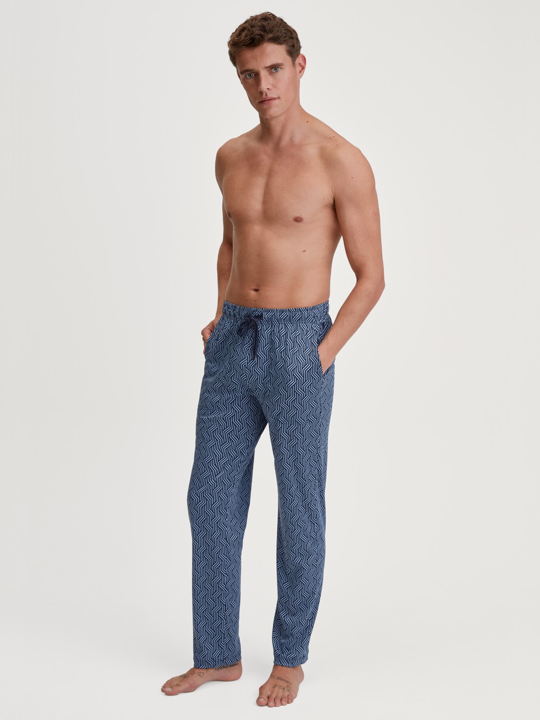 Herren-Model trägt Pyjamahose mit Seitentaschen aus Baumwolle in Blau, Gemustert aus Serie RMX Sleep Free von CALIDA, Outfit