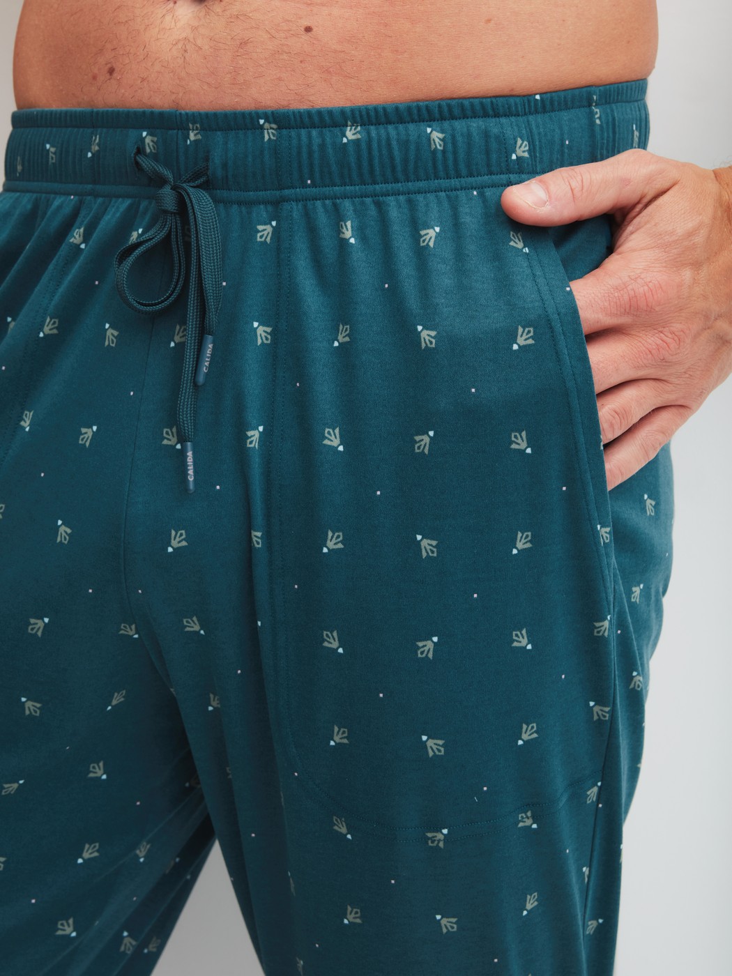 Herren-Model trägt Pyjamahose mit Seitentaschen aus Baumwolle in Türkis, Gemustert aus Serie RMX Sleep Free von CALIDA, Detail