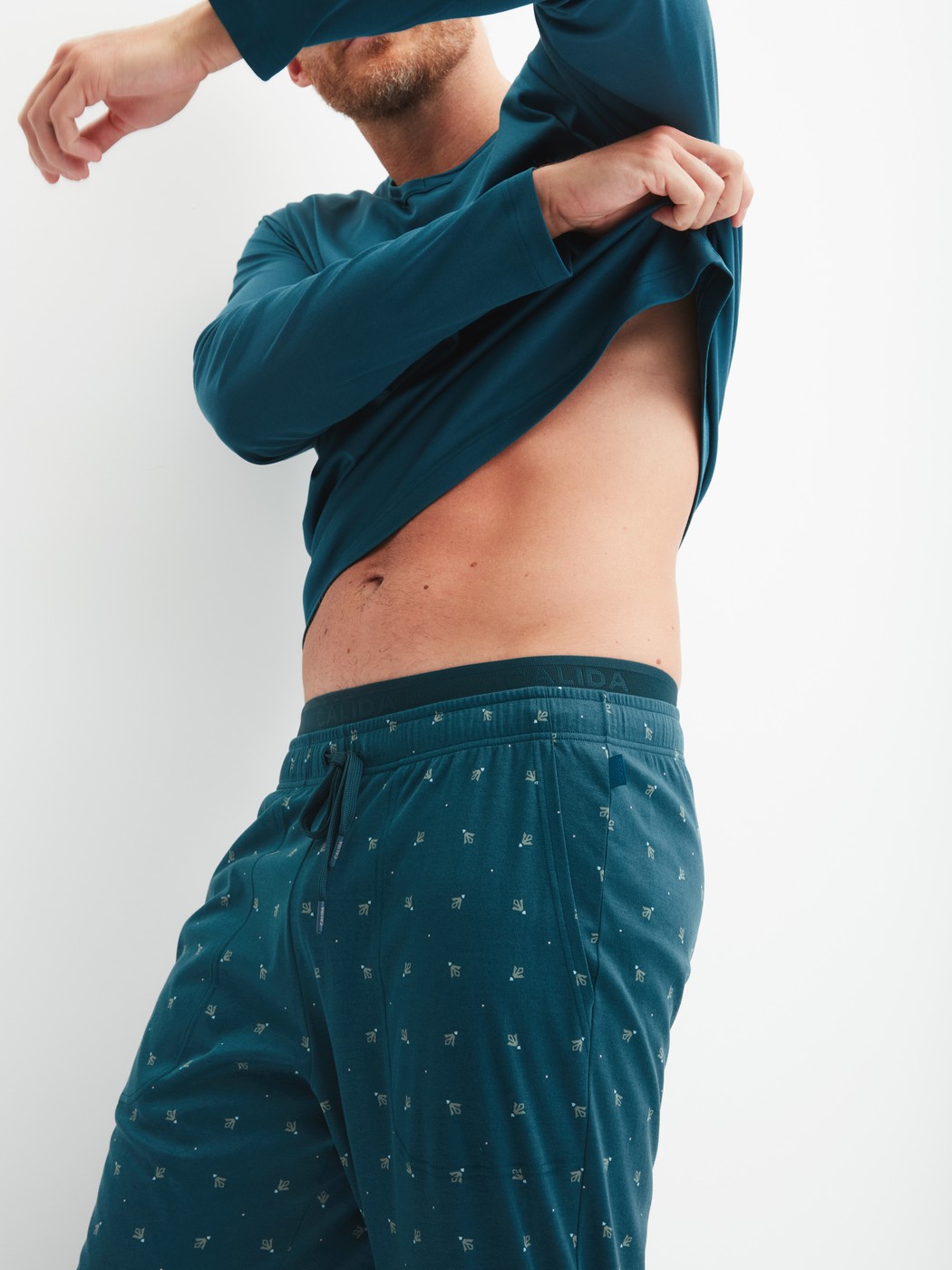 Herren-Model trägt Pyjamahose mit Seitentaschen aus Baumwolle in Türkis, Gemustert aus Serie RMX Sleep Free von CALIDA, Zusatzbild
