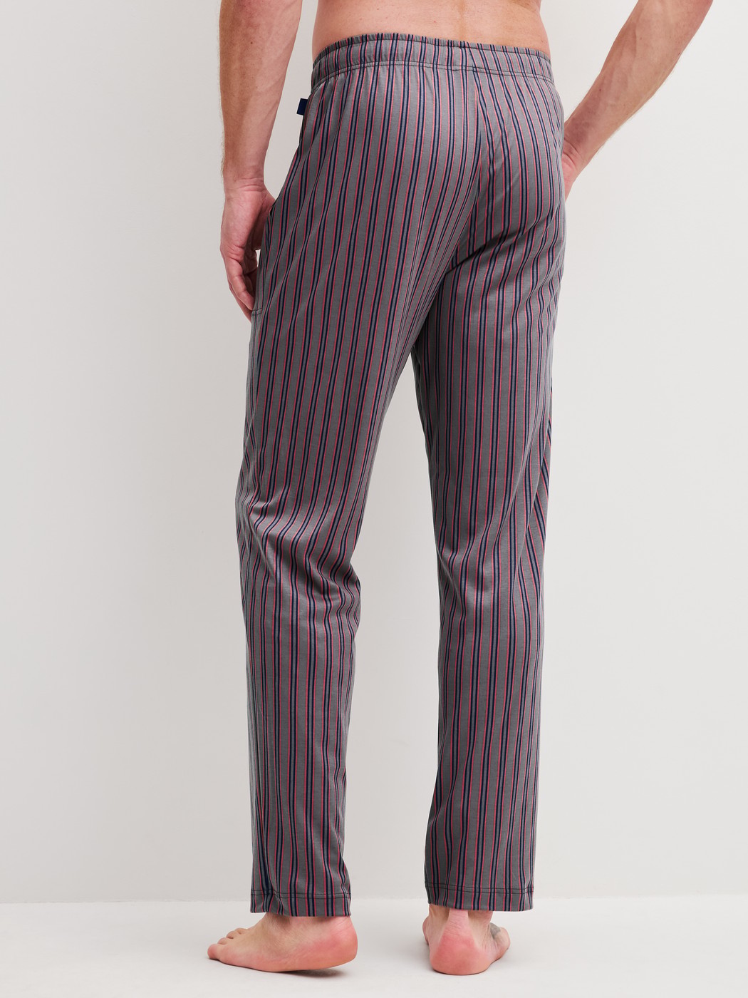 Herren-Model trägt Pyjamahose mit Seitentaschen aus Baumwolle in Braun, Gestreift aus Serie RMX Sleep Superlight von CALIDA, Rückansicht