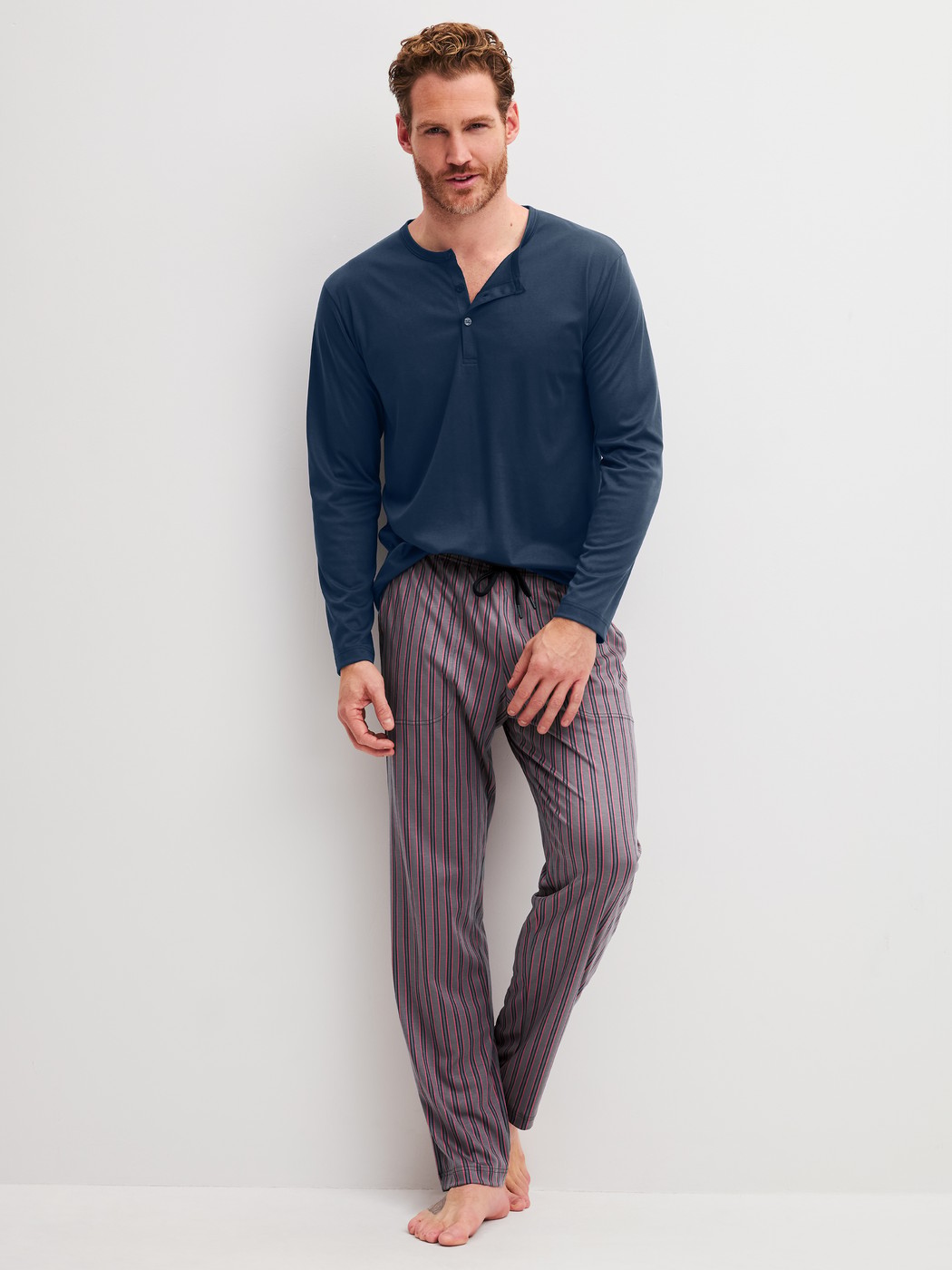 Herren-Model trägt Pyjamahose mit Seitentaschen aus Baumwolle in Braun, Gestreift aus Serie RMX Sleep Superlight von CALIDA, Outfit