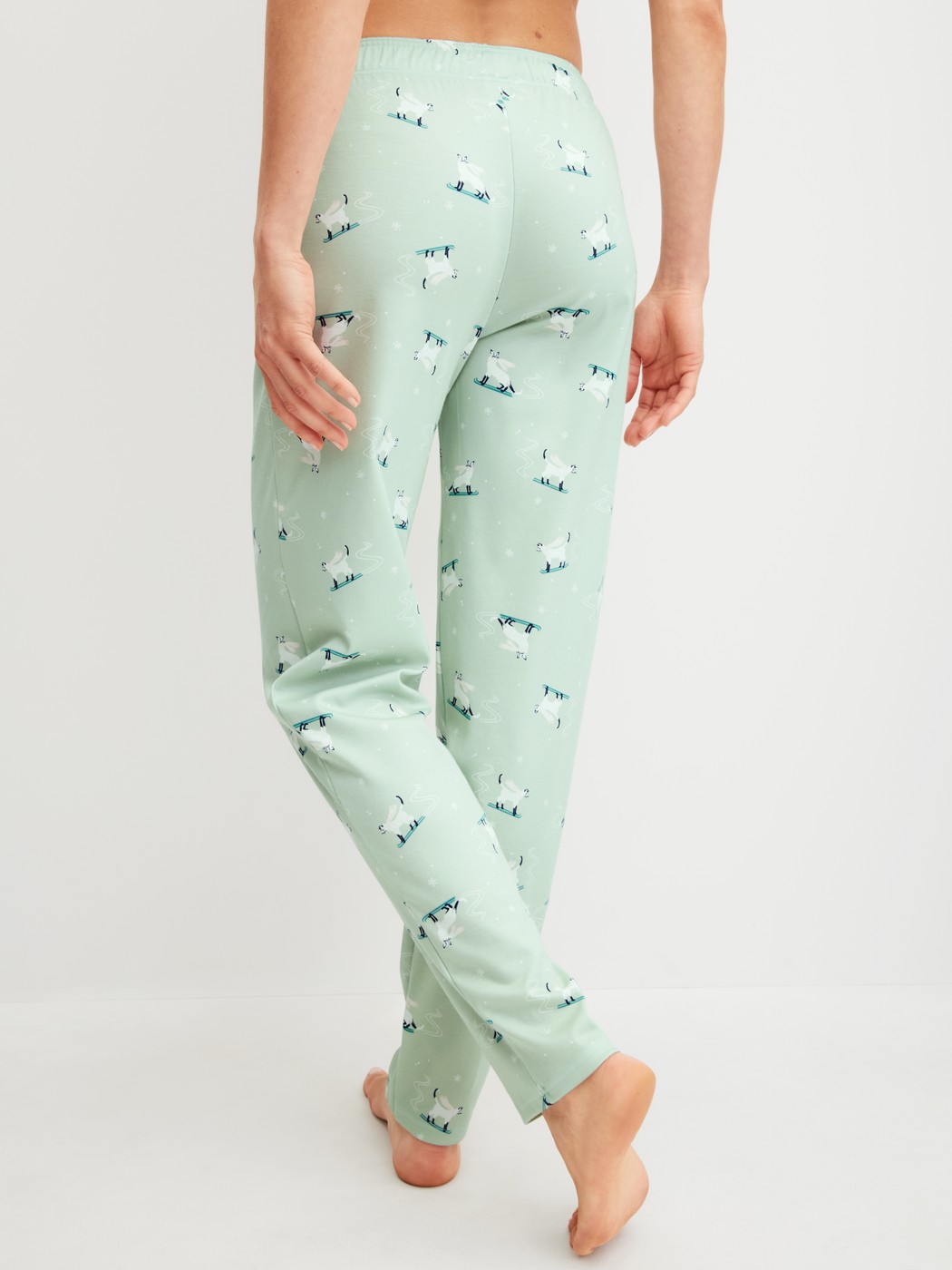 Damen-Model trägt Pyjamahose mit Seitentaschen aus 100% Baumwolle in Grün, Motiv aus Serie Favourites Cats von CALIDA, Rückansicht