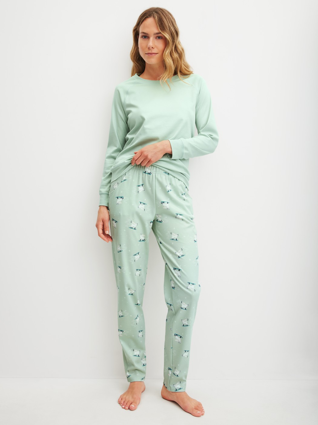 Damen-Model trägt Pyjamahose mit Seitentaschen aus 100% Baumwolle in Grün, Motiv aus Serie Favourites Cats von CALIDA, Outfit