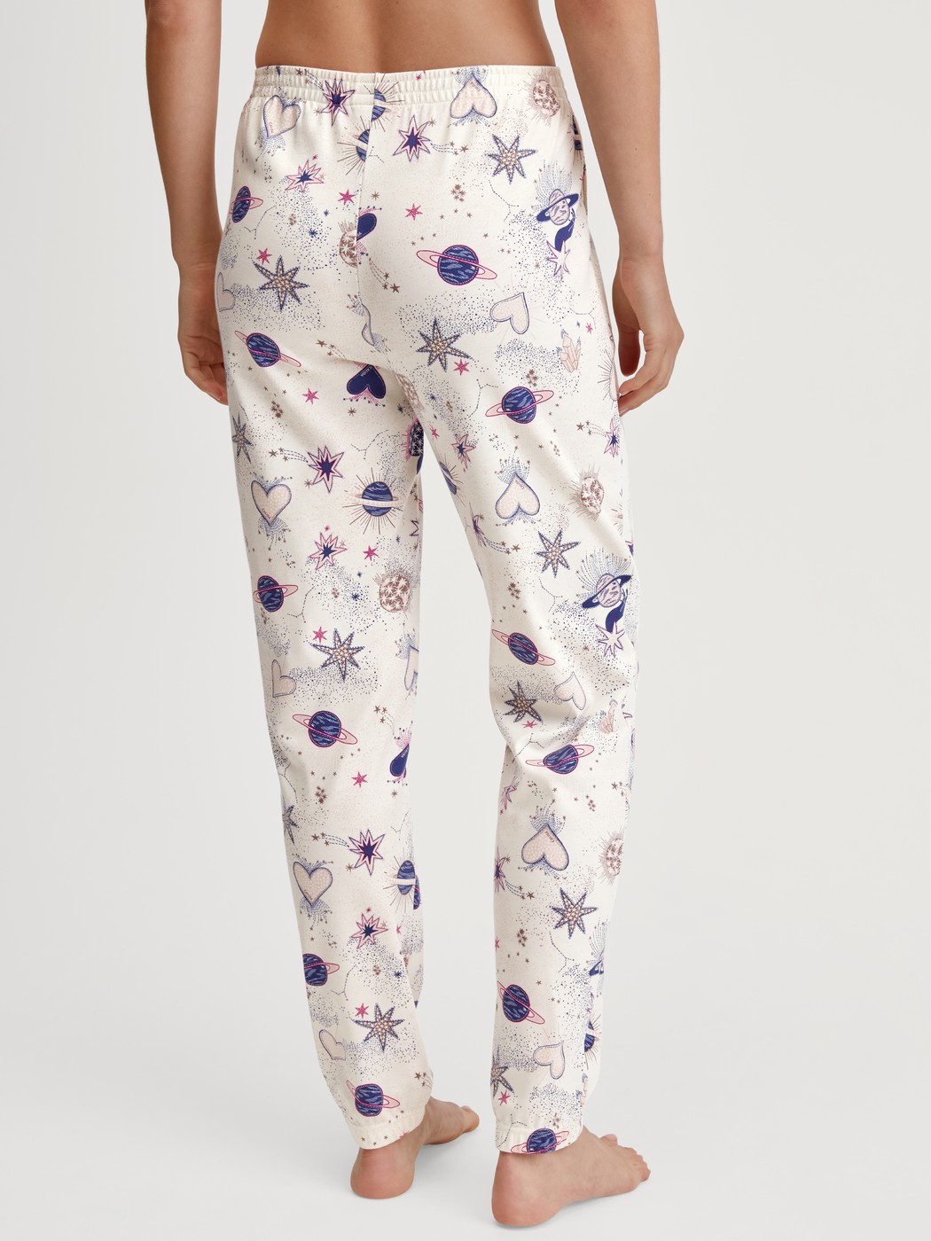 Damen-Model trägt Pyjamahose mit Bündchen aus 100% Baumwolle in Beige, Gemustert aus Serie Favourites Universe von CALIDA, Rückansicht