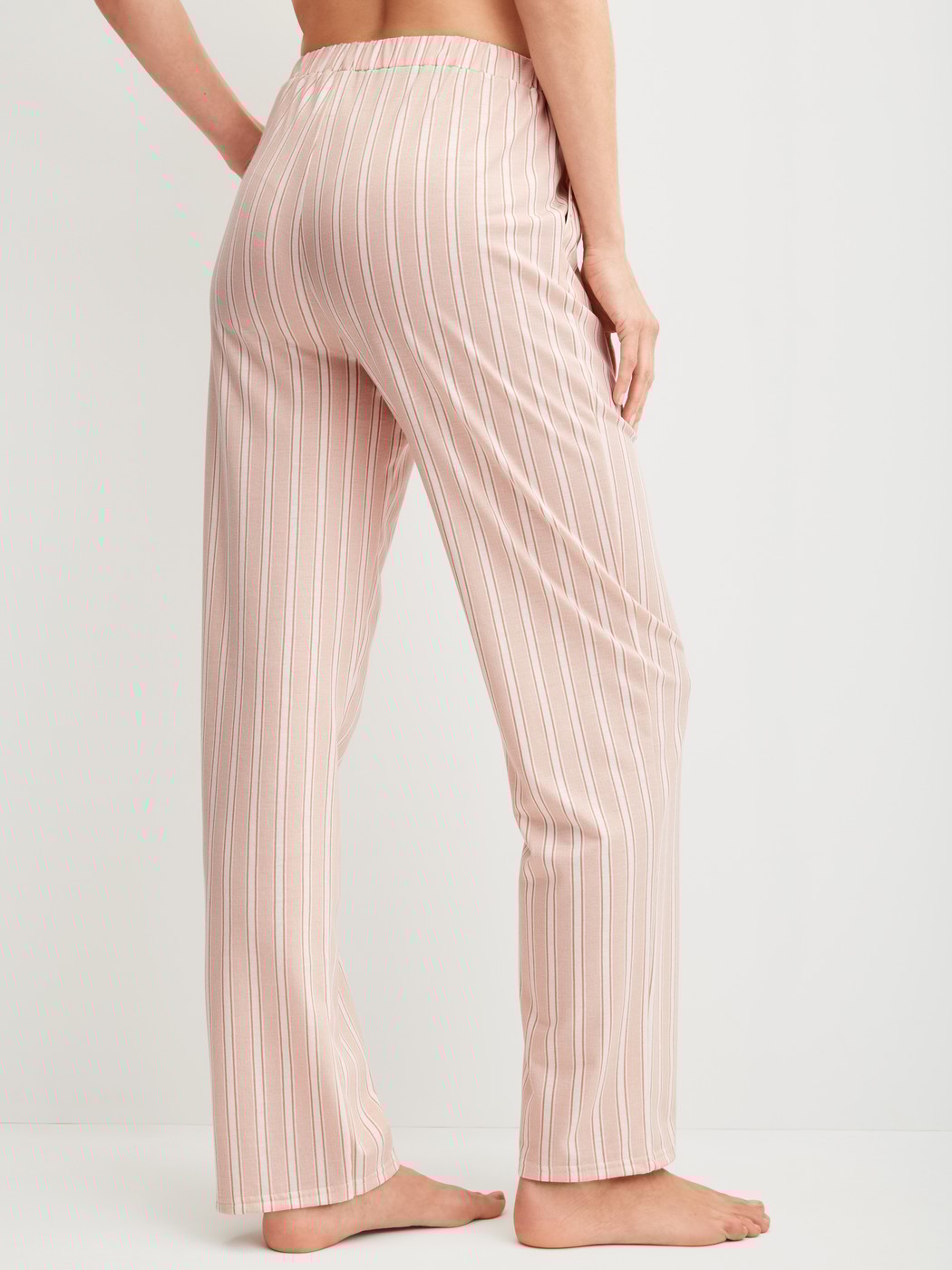 Damen-Model trägt Pyjamahose mit Seitentaschen aus Baumwolle in Beige, Gestreift aus Serie Favourites Arts von CALIDA, Rückansicht