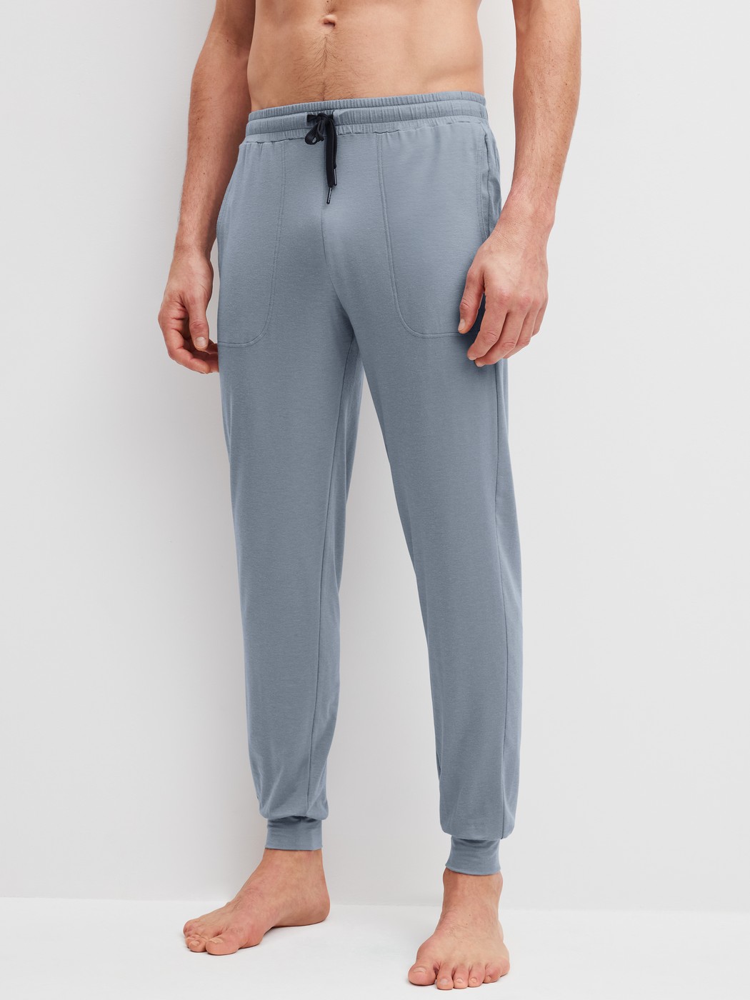 Men model is wearing Pyjama bottom with cuffs made of Lyocell in Grey, Unicoloured from the DSW Warming series by CALIDA, Front view