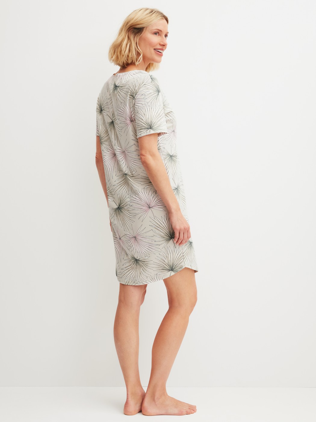 Women model is wearing Short-sleeved nightdress, length 95 cm made of 100% Cotton in Green, Floral from the Leaf Dreams series by CALIDA, Back view