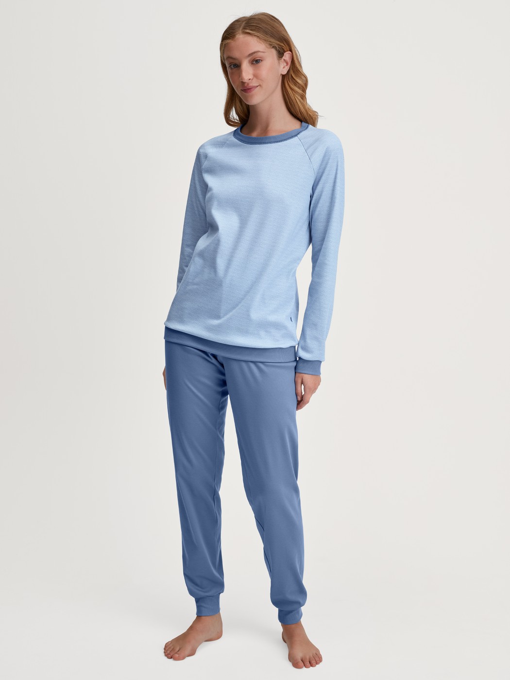 Damen-Model trägt Bündchen-Pyjama aus 100% Baumwolle in Blau, Gestreift aus Serie Midnight Stripes von CALIDA, Vorderansicht