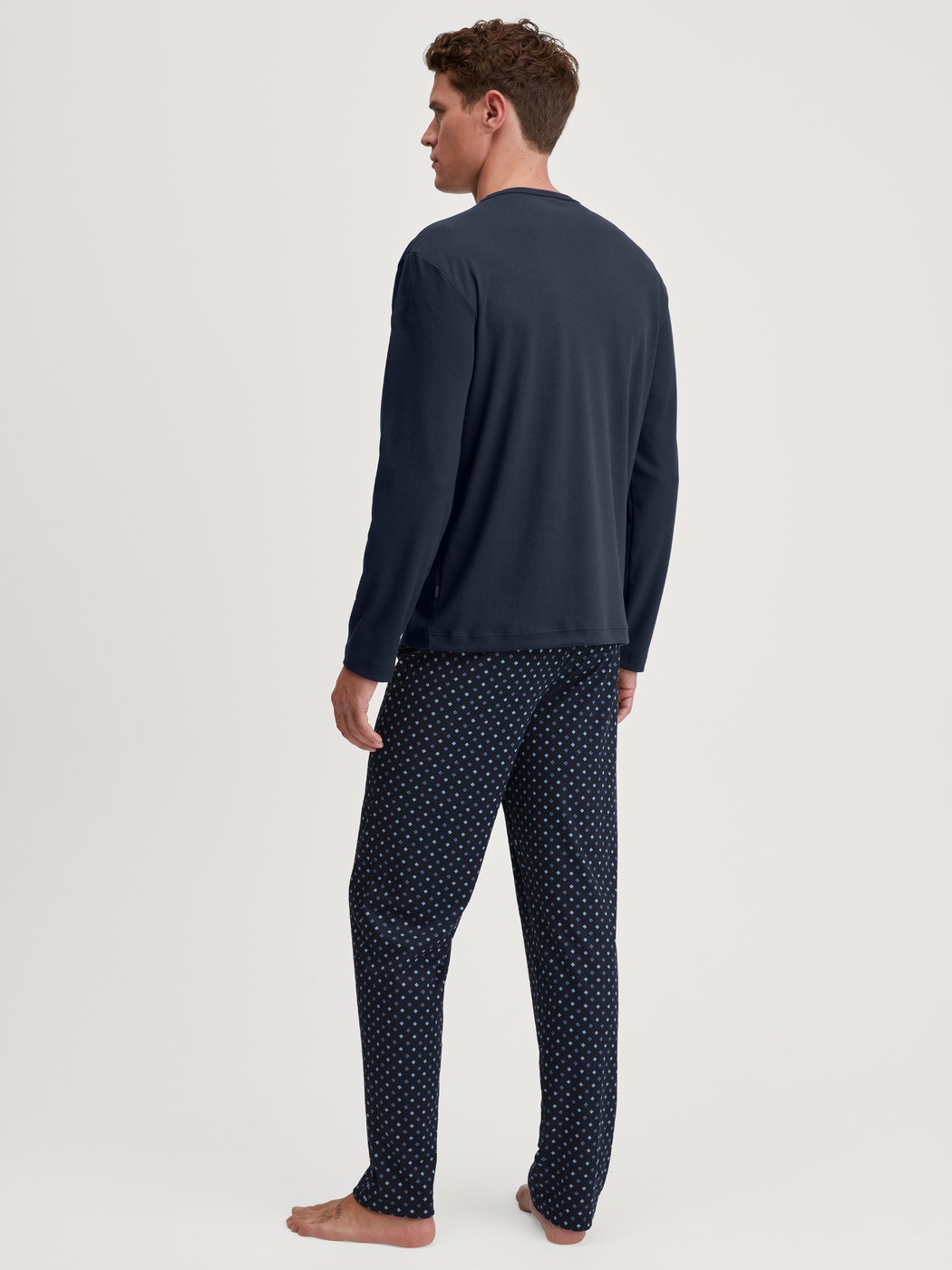 Men model is wearing Pyjamas, long made of 100% Cotton in Blue, Patterned from the Relax Streamline series by CALIDA, Back view