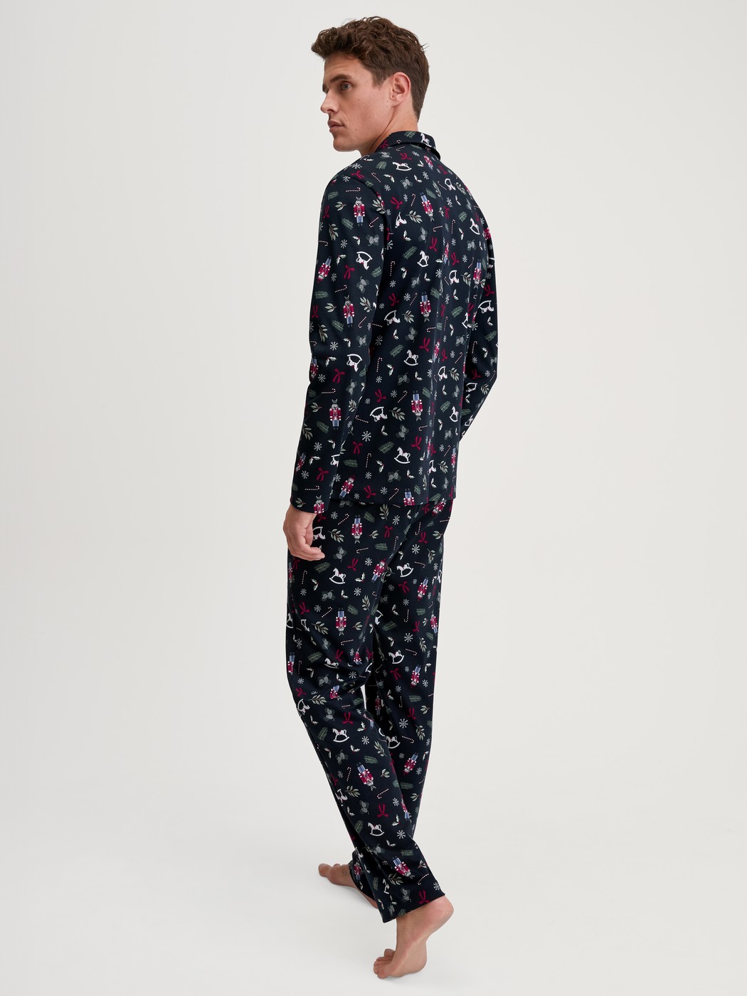 Herren-Model trägt Pyjama mit Knöpfen aus 100% Baumwolle in Blau, Gemustert aus Serie Family & Friends von CALIDA, Rückansicht