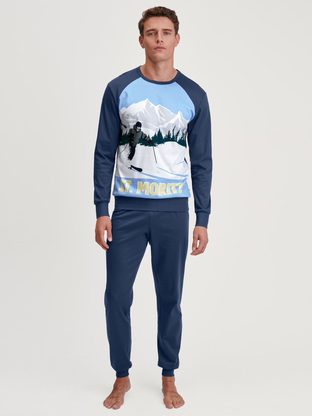 Men model is wearing Pyjama with cuff made of 100% Cotton in Blue, Motif from the Relax Ski Resort series by CALIDA, Front view