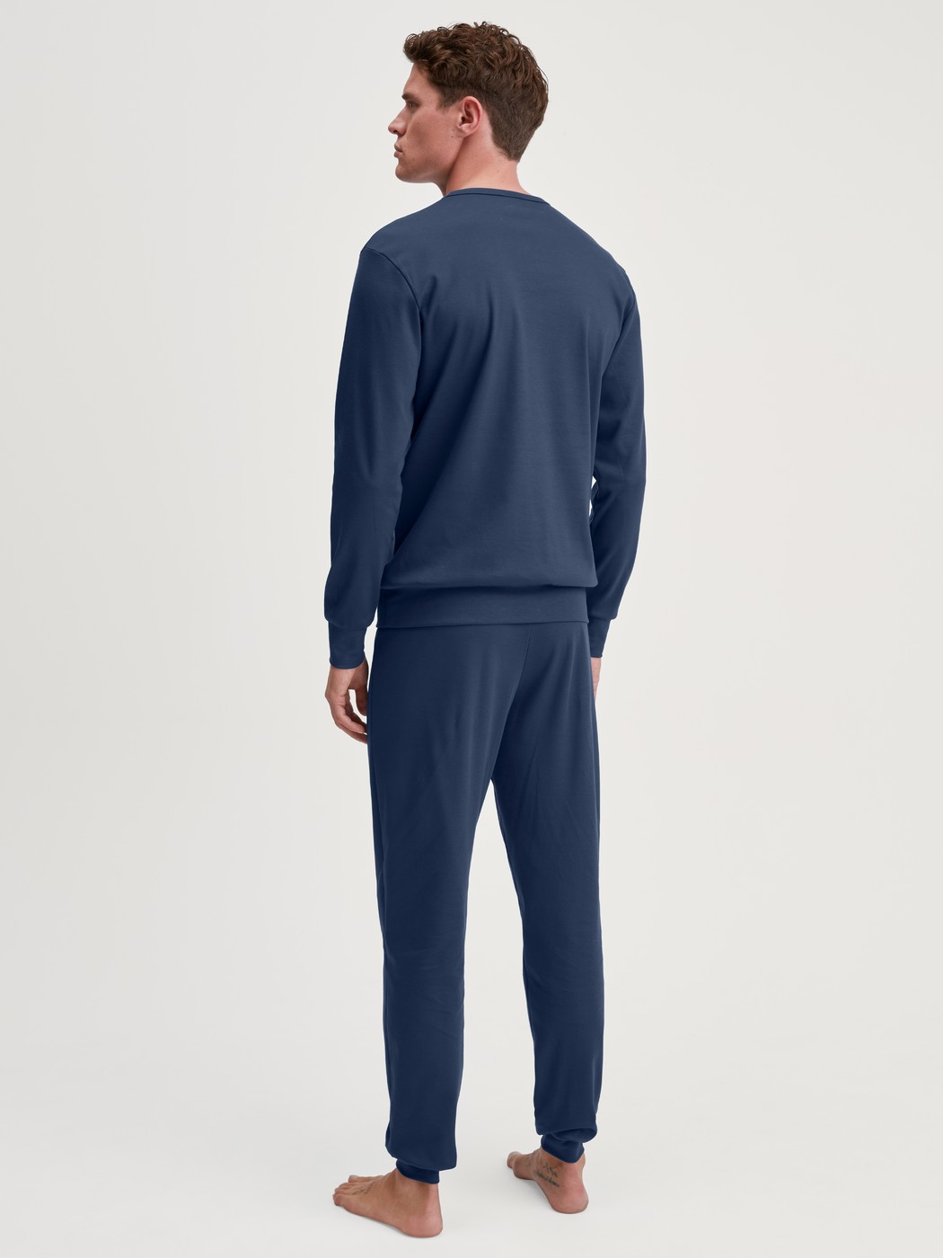 Men model is wearing Pyjama with cuff made of 100% Cotton in Blue, Motif from the Relax Ski Resort series by CALIDA, Back view