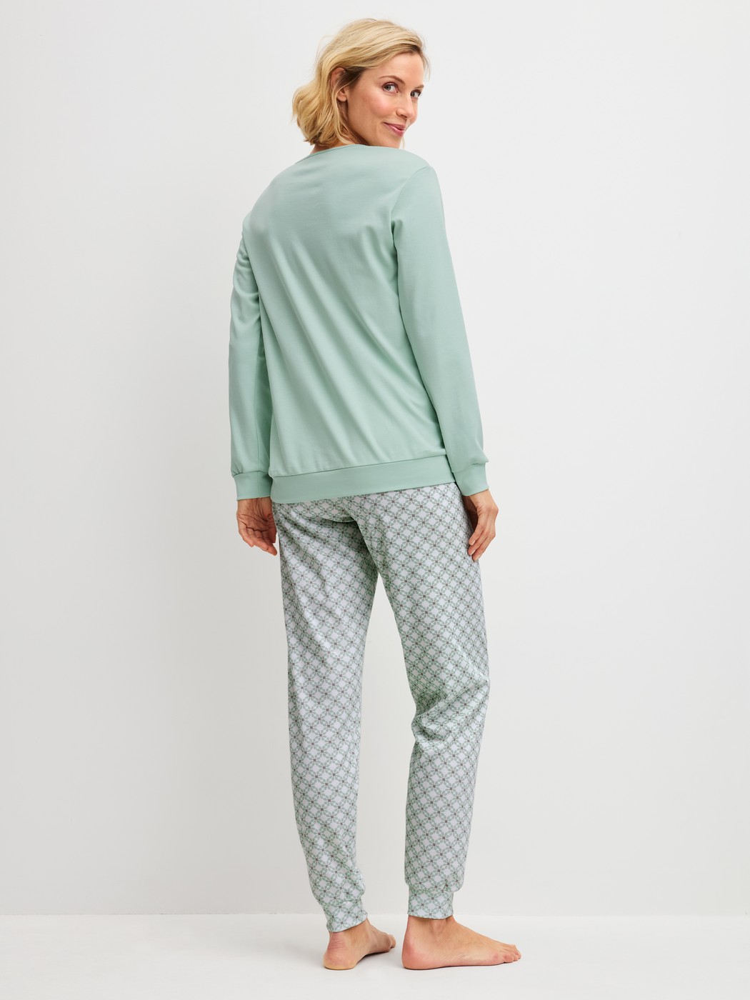 Women model is wearing Pyjama with cuff made of 100% Cotton in Turquoise, Patterned from the Sweet Dreams series by CALIDA, Back view