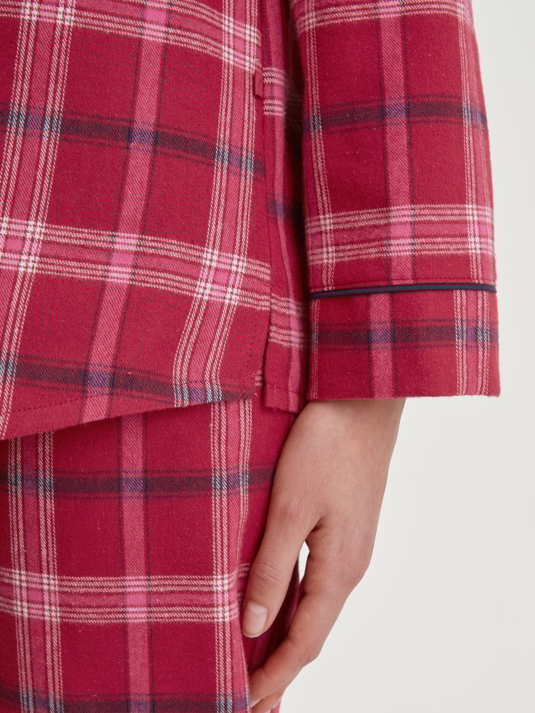 Damen-Model trägt Flanell-Pyjama mit Knöpfen aus 100% Baumwolle in Rot, Kariert aus Serie Holiday Dreams von CALIDA, Detail