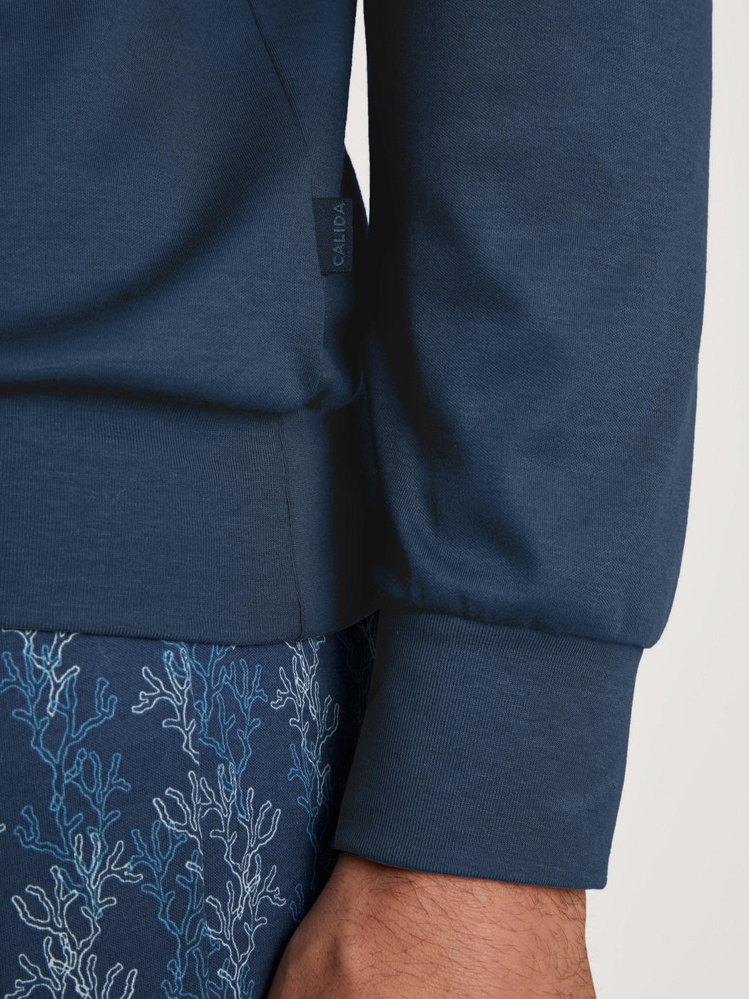 Herren-Model trägt Bündchen-Pyjama aus 100% Baumwolle in Blau, Gemustert aus Serie Nightwear Xtra von CALIDA, Detail