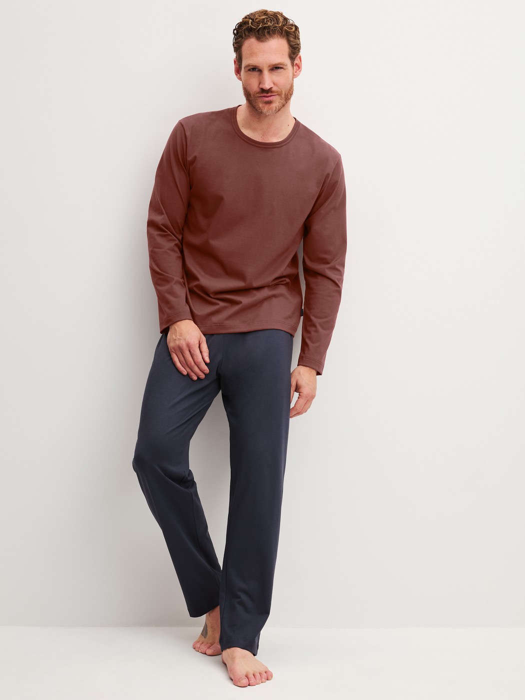 Herren-Model trägt Pyjama, lang aus 100% Baumwolle in Rot, Einfarbig aus Serie Relax Essentials von CALIDA, Vorderansicht
