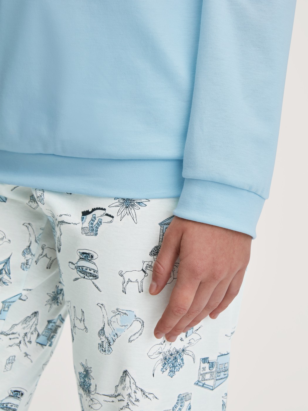 Damen-Model trägt Bündchen-Pyjama aus 100% Baumwolle in Blau, Gemustert aus Serie Swiss Resort von CALIDA, Detail