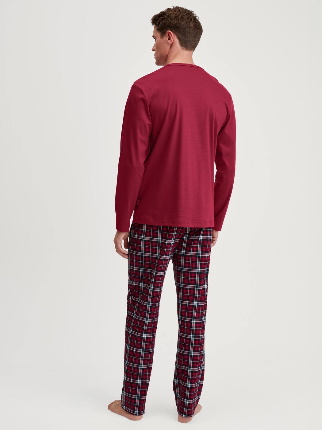 Herren-Model trägt Pyjama, lang aus 100% Baumwolle in Rot, Kariert aus Serie Family & Friends von CALIDA, Rückansicht