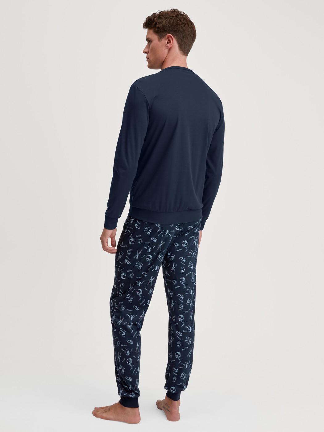 Herren-Model trägt Bündchen-Pyjama aus 100% Baumwolle in Blau, Gemustert aus Serie Relax Swiss Resort von CALIDA, Rückansicht