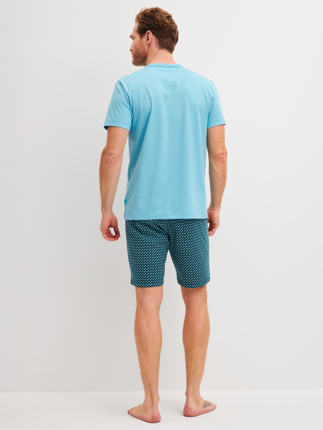 Herren-Model trägt Kurz-Pyjama aus 100% Baumwolle in Blau, Gemustert aus Serie Cotton Special von CALIDA, Rückansicht