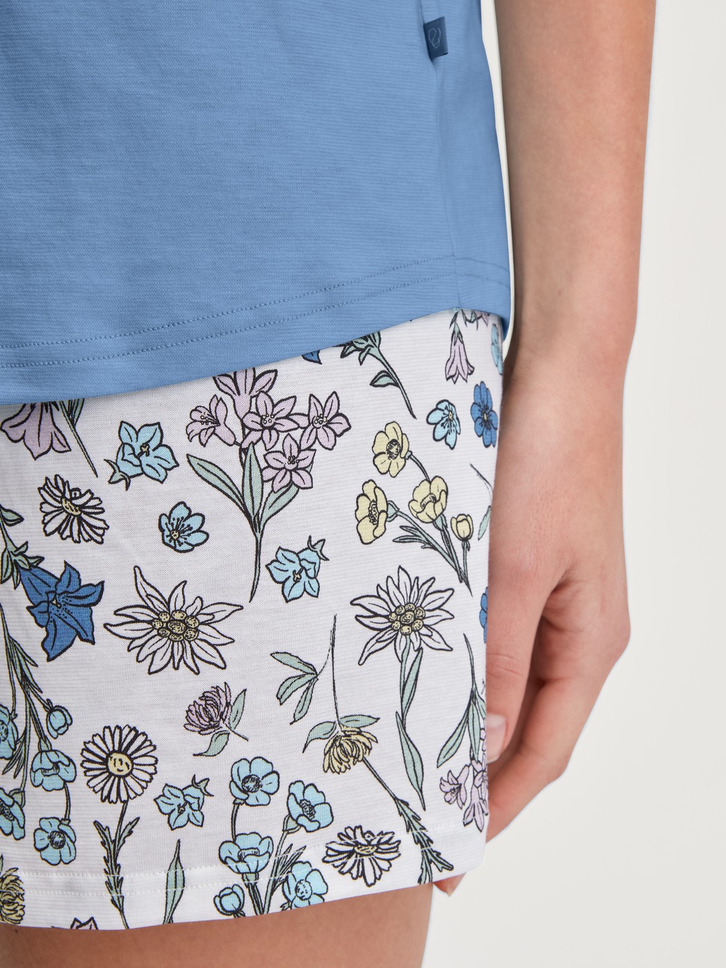 Damen-Model trägt Kurz-Pyjama aus 100% Baumwolle in Blau, Floral aus Serie Flower Nights von CALIDA, Detail