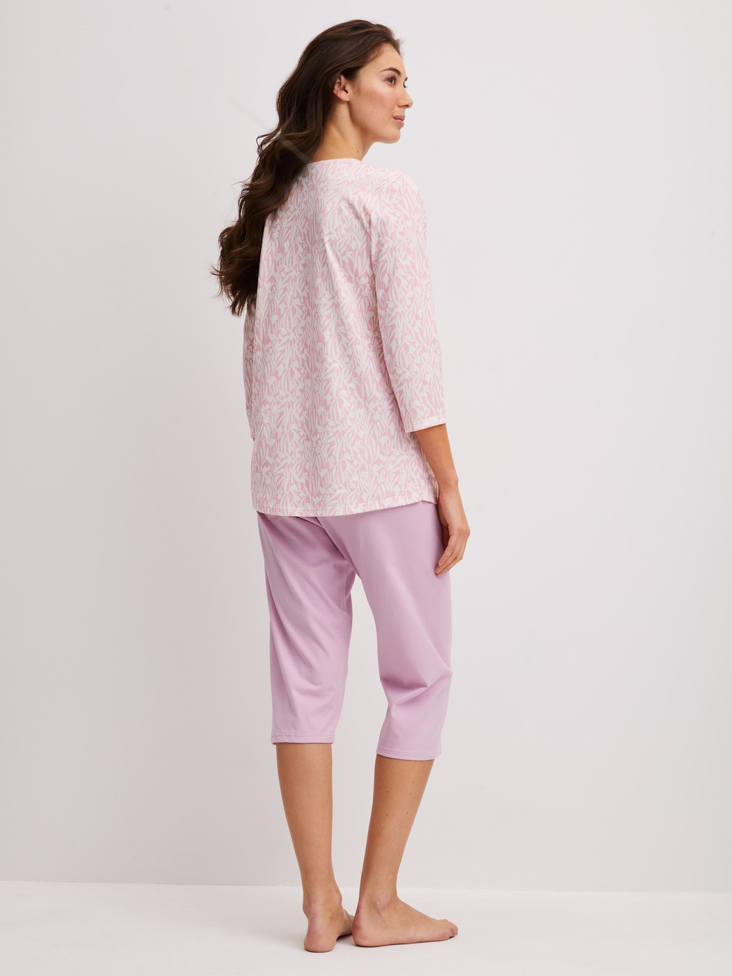 La modella / Il modello Donna indossa Pigiama capri in 100% cotone di colore Viola, Modello, della serie Blooming Nights di CALIDA, Vista posteriore