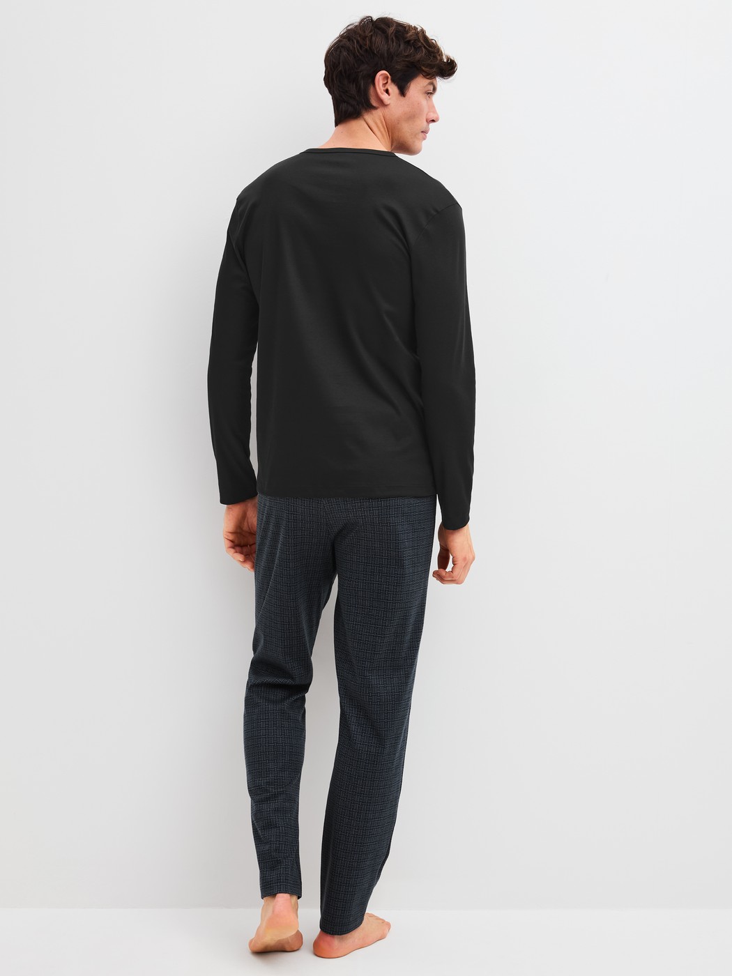 Men model is wearing Pyjamas, long made of 100% Cotton in Black, Patterned from the Relax Streamline 2 series by CALIDA, Back view