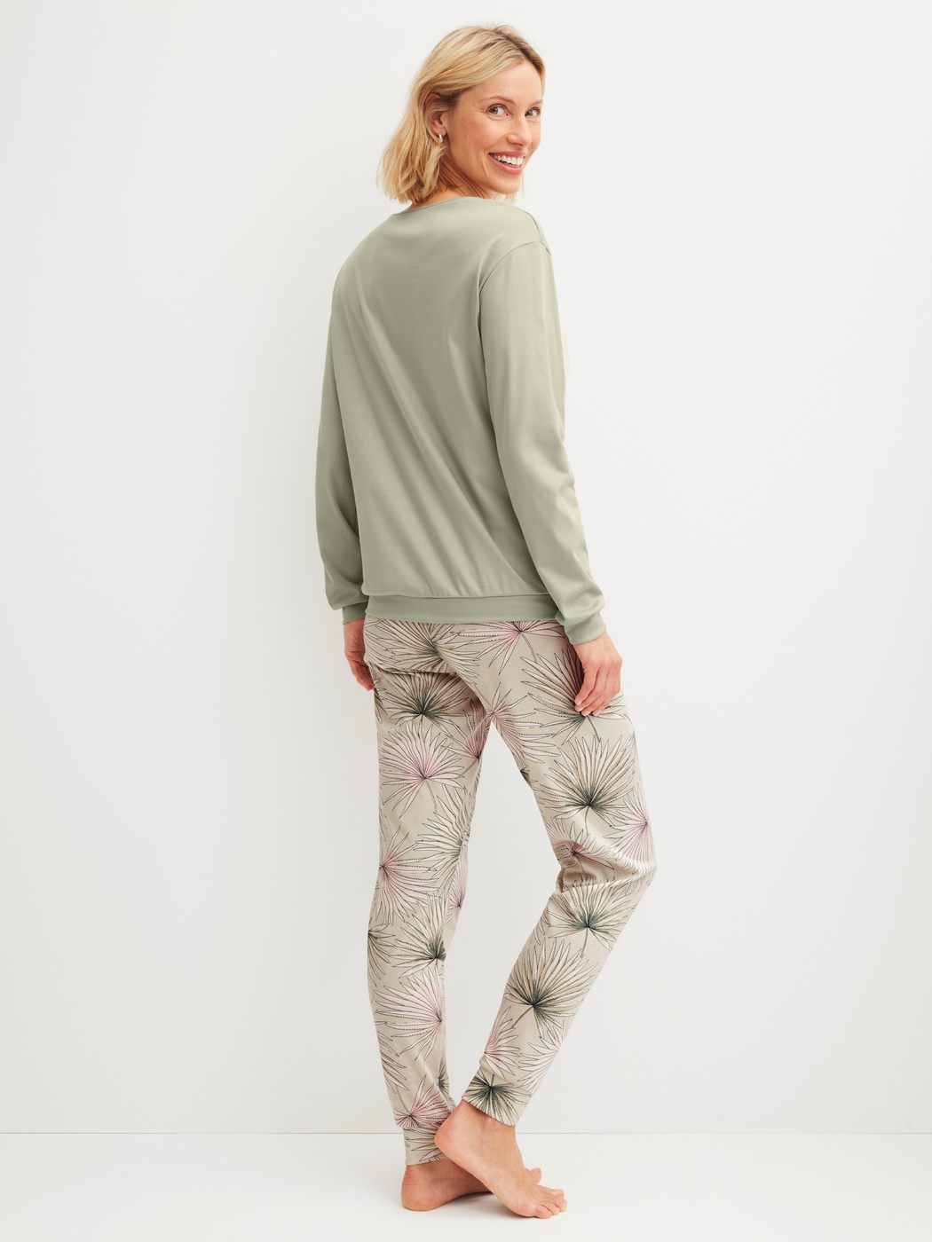 Women model is wearing Pyjama with cuff made of 100% Cotton in Green, Floral from the Leaf Dreams series by CALIDA, Back view