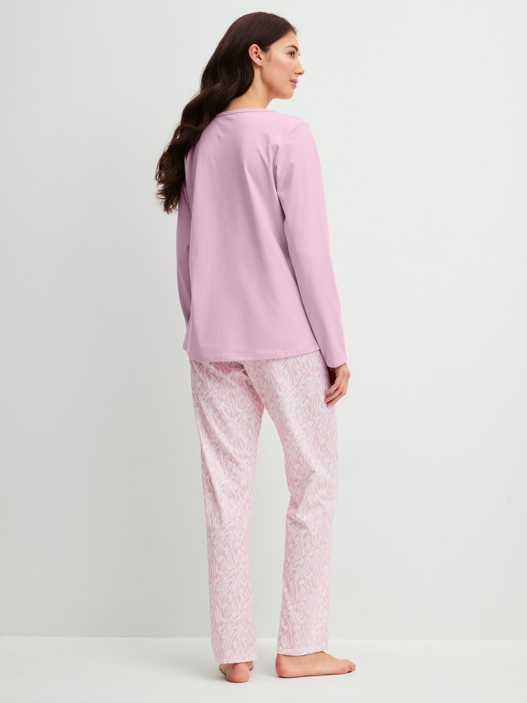 Damen-Model trägt Pyjama, lang aus 100% Baumwolle in Violett, Gemustert aus Serie Blooming Nights von CALIDA, Rückansicht